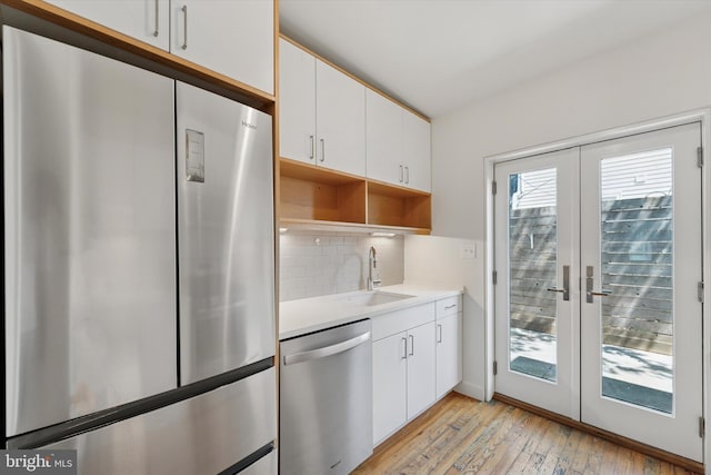 439 Mercy St, Philadelphia, PA 19148 - kitchen with appliances with stainless steel finishes, french doors, light wood-style flooring, backsplash, and light countertops