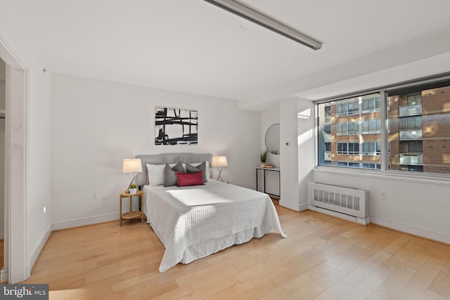 800 4th St SW Unit N216, Washington, DC 20024 - bedroom with radiator heating unit, wood finished floors, and baseboards