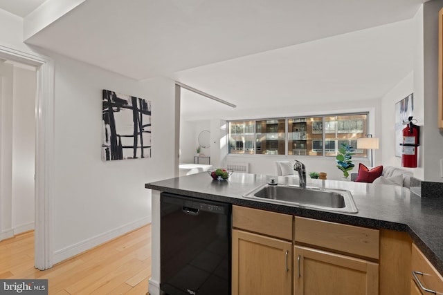 800 4th St SW Unit N216, Washington, DC 20024 - kitchen featuring black dishwasher, a sink, dark countertops, light wood-style flooring, and baseboards