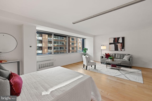 800 4th St SW Unit N216, Washington, DC 20024 - bedroom featuring radiator, wood finished floors, and baseboards