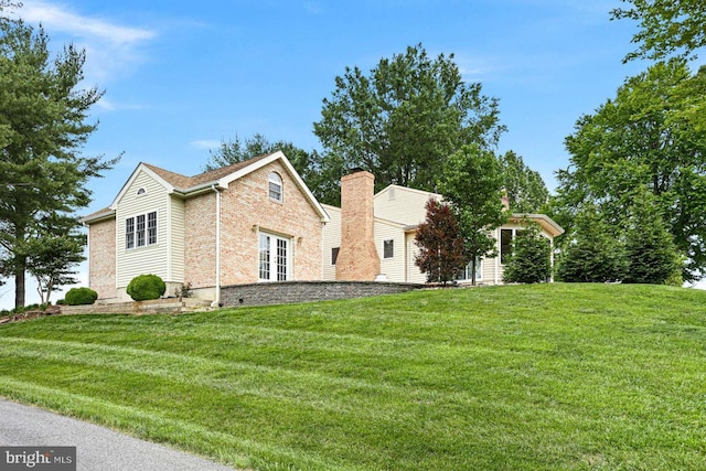 536 Dawson Trak, Hockessin, DE 19707 - view of side of property featuring a lawn, brick siding, french doors, and a chimney