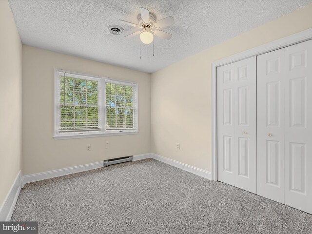 182 Humphrey Ln, Falling Waters, WV 25419 - unfurnished bedroom with a textured ceiling, a baseboard heating unit, carpet flooring, a closet, and a ceiling fan