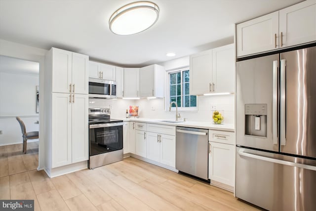 944 War Admiral St, Great Falls, VA 22066 - kitchen featuring appliances with stainless steel finishes, a sink, backsplash, light countertops, and white cabinetry