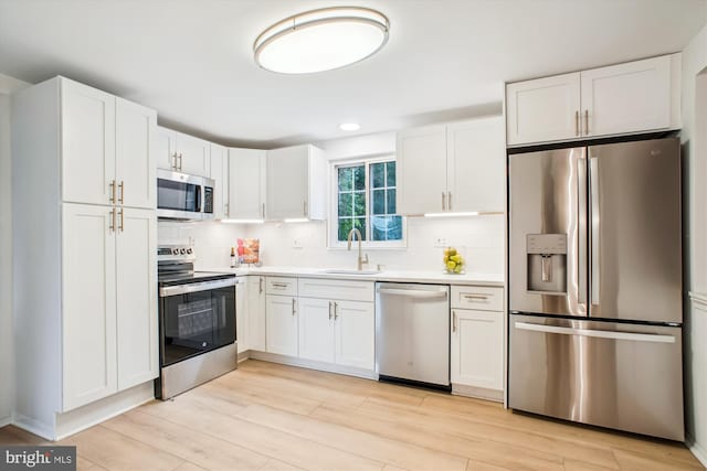 944 War Admiral St, Great Falls, VA 22066 - kitchen with stainless steel appliances, a sink, white cabinetry, light countertops, and decorative backsplash