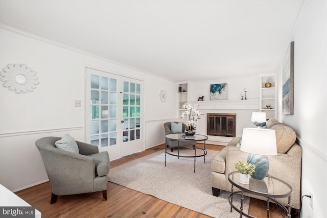 944 War Admiral St, Great Falls, VA 22066 - living area featuring wood finished floors, a glass covered fireplace, crown molding, french doors, and built in shelves