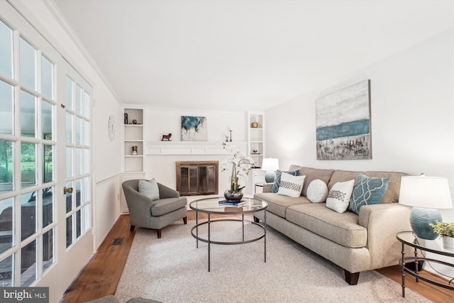 944 War Admiral St, Great Falls, VA 22066 - living room with wood finished floors, built in features, and a glass covered fireplace
