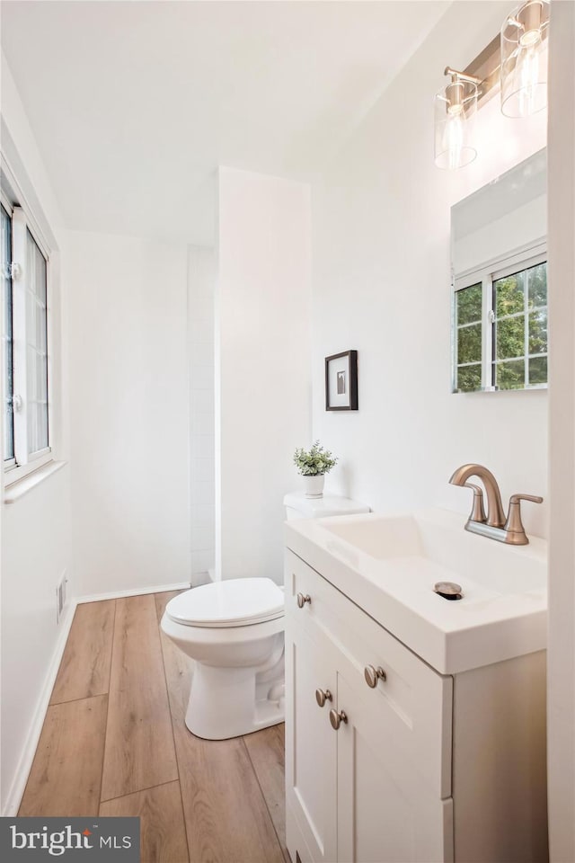 944 War Admiral St, Great Falls, VA 22066 - bathroom with toilet, vanity, wood finished floors, and baseboards