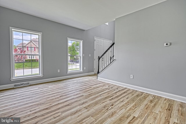 1201 Falls Grove Ln, York, PA 17404 - unfurnished living room featuring light wood-style flooring, baseboards, and stairs