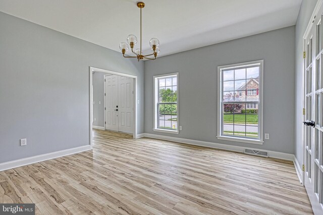 1201 Falls Grove Ln, York, PA 17404 - empty room featuring a chandelier, light wood-style flooring, and baseboards