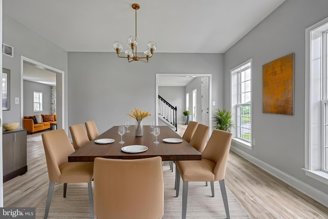 1201 Falls Grove Ln, York, PA 17404 - dining space with light wood-style floors, a chandelier, baseboards, and stairs