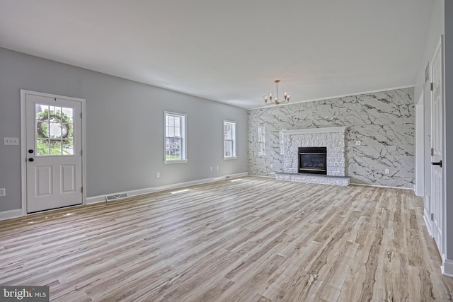 1201 Falls Grove Ln, York, PA 17404 - unfurnished living room with healthy amount of natural light, a chandelier, and wood finished floors