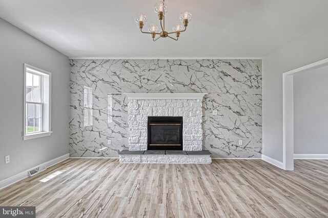 1201 Falls Grove Ln, York, PA 17404 - unfurnished living room featuring an accent wall, a chandelier, a fireplace, and baseboards