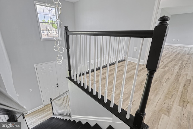 1201 Falls Grove Ln, York, PA 17404 - stairway featuring wood finished floors, a chandelier, and baseboards