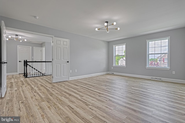 1201 Falls Grove Ln, York, PA 17404 - empty room with a chandelier, wood finished floors, baseboards, and a smoke detector