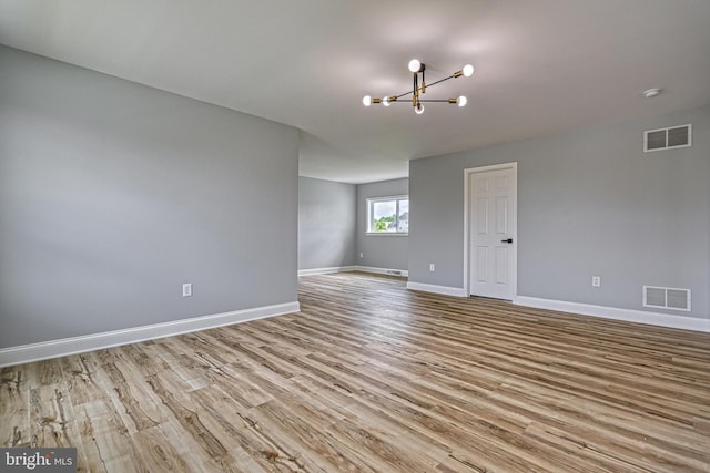 1201 Falls Grove Ln, York, PA 17404 - spare room featuring a chandelier, wood finished floors, and baseboards