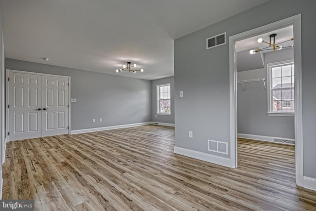 1201 Falls Grove Ln, York, PA 17404 - unfurnished bedroom featuring a chandelier, wood finished floors, a closet, and baseboards