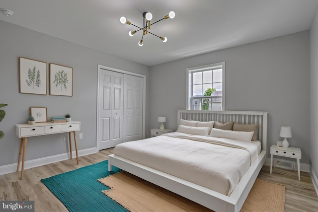 1201 Falls Grove Ln, York, PA 17404 - bedroom with a chandelier, light wood finished floors, a closet, and baseboards