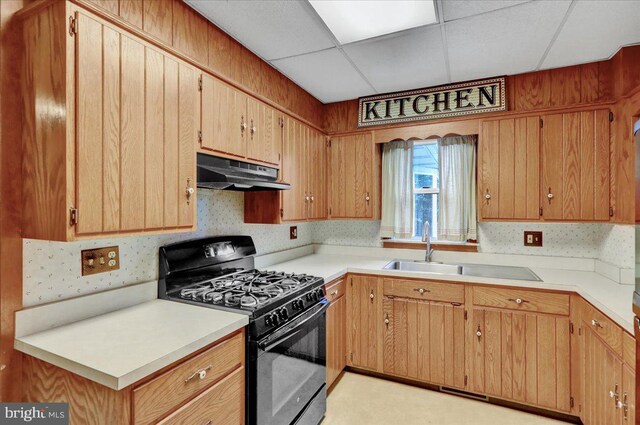 64 W Fairview St, Mohnton, PA 19540 - kitchen with black gas range oven, under cabinet range hood, light countertops, a sink, and a paneled ceiling