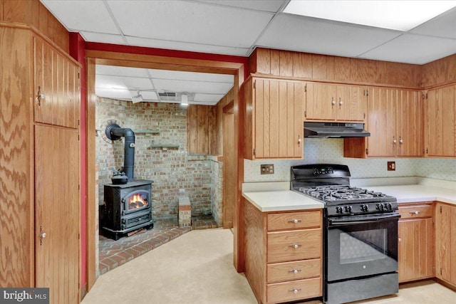 64 W Fairview St, Mohnton, PA 19540 - kitchen with gas stove, a paneled ceiling, under cabinet range hood, light countertops, and a wood stove