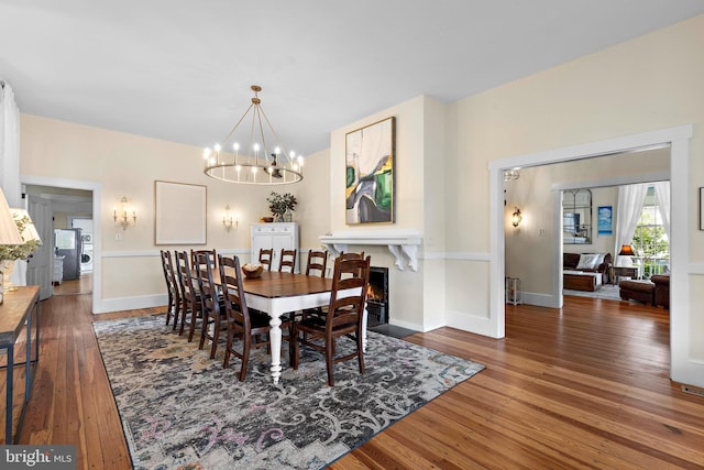 123 Coral St, Beach Haven, NJ 08008 - dining area with hardwood / wood-style flooring, a chandelier, baseboards, and washer / dryer