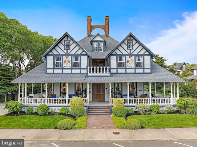 123 Coral St, Beach Haven, NJ 08008 - view of front of house with covered porch, a shingled roof, a front yard, and a chimney
