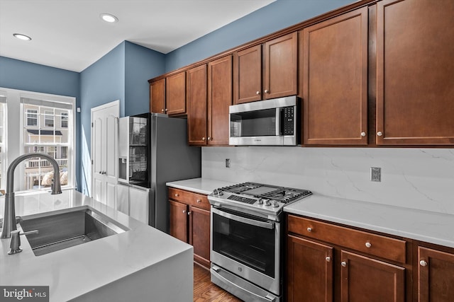 22650 Gray Falcon, Ashburn, VA 20148 - kitchen featuring stainless steel appliances, a sink, light countertops, backsplash, and recessed lighting