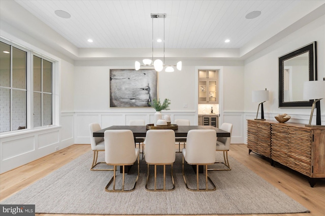 6613 Byrnes Dr, Mclean, VA 22101 - dining room featuring light wood-type flooring, a decorative wall, wooden ceiling, wainscoting, and a chandelier
