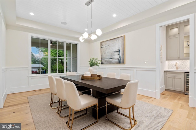 6613 Byrnes Dr, Mclean, VA 22101 - dining area featuring wine cooler, light wood-type flooring, a decorative wall, recessed lighting, and wainscoting