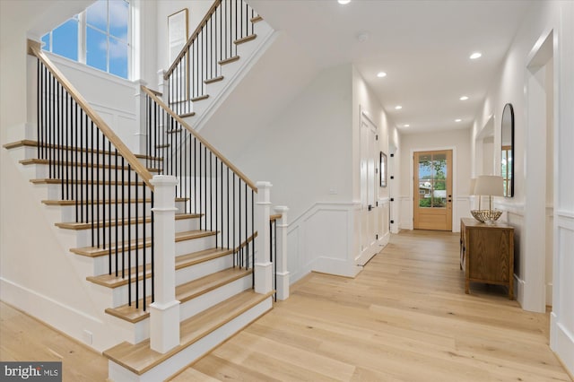 6613 Byrnes Dr, Mclean, VA 22101 - foyer entrance with light wood-type flooring, a decorative wall, stairway, recessed lighting, and a wainscoted wall