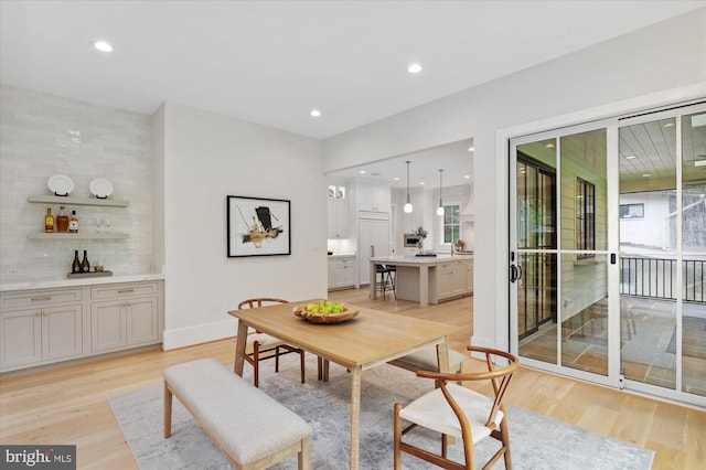 6613 Byrnes Dr, Mclean, VA 22101 - dining room with healthy amount of natural light, light wood-style flooring, recessed lighting, a bar, and baseboards
