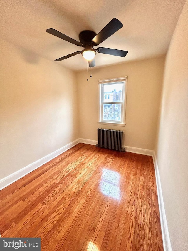 3925 Colborne Rd, Baltimore, MD 21229 - spare room featuring radiator heating unit, wood finished floors, a ceiling fan, and baseboards