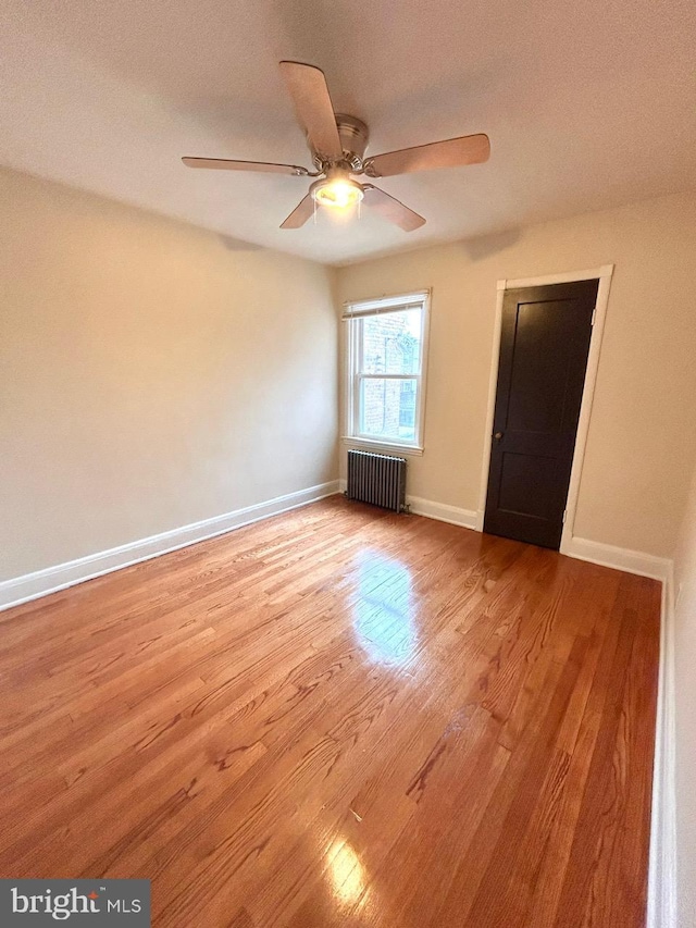 3925 Colborne Rd, Baltimore, MD 21229 - spare room featuring radiator, wood finished floors, a ceiling fan, and baseboards