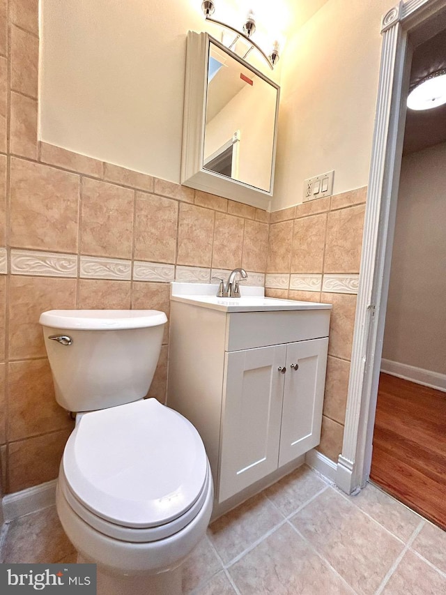 3925 Colborne Rd, Baltimore, MD 21229 - bathroom with tile walls, vanity, toilet, tile patterned flooring, and a wainscoted wall