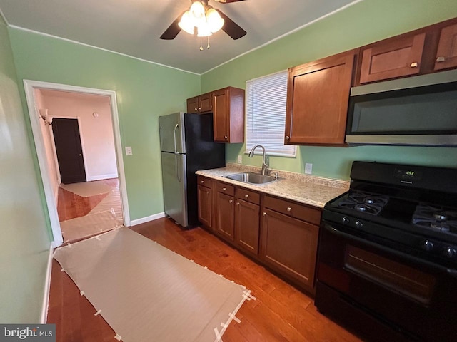 3925 Colborne Rd, Baltimore, MD 21229 - kitchen with appliances with stainless steel finishes, a sink, light countertops, light wood-style floors, and ceiling fan