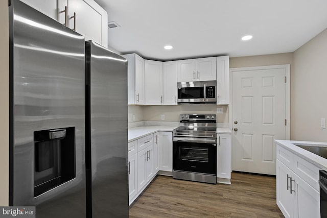5210 57th Ave, Hyattsville, MD 20781 - kitchen featuring appliances with stainless steel finishes, light countertops, white cabinets, dark wood-style floors, and recessed lighting