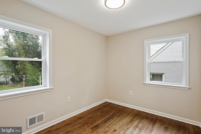 5210 57th Ave, Hyattsville, MD 20781 - empty room with healthy amount of natural light, dark wood-type flooring, and baseboards