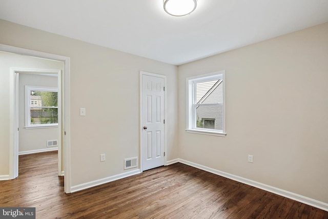 5210 57th Ave, Hyattsville, MD 20781 - unfurnished bedroom featuring baseboards, dark wood-style flooring, multiple windows, and a closet
