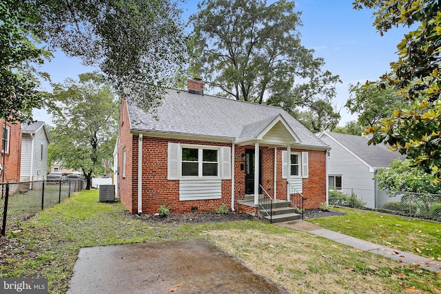 5210 57th Ave, Hyattsville, MD 20781 - view of front of property with brick siding, cooling unit, a chimney, and roof with shingles