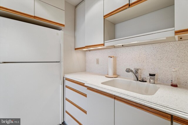 50 Belmont Ave Unit 1016/1116, Bala Cynwyd, PA 19004 - kitchen featuring freestanding refrigerator, a sink, decorative backsplash, and white cabinetry