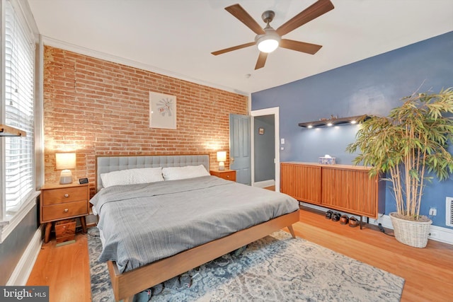 615 W Marion St, Lancaster, PA 17603 - bedroom with brick wall, an accent wall, wood finished floors, baseboards, and ceiling fan