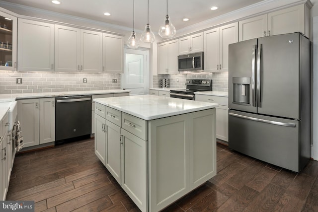 1704 N Royal Ave, Front Royal, VA 22630 - kitchen featuring appliances with stainless steel finishes, dark wood-style flooring, a kitchen island, light countertops, and decorative backsplash