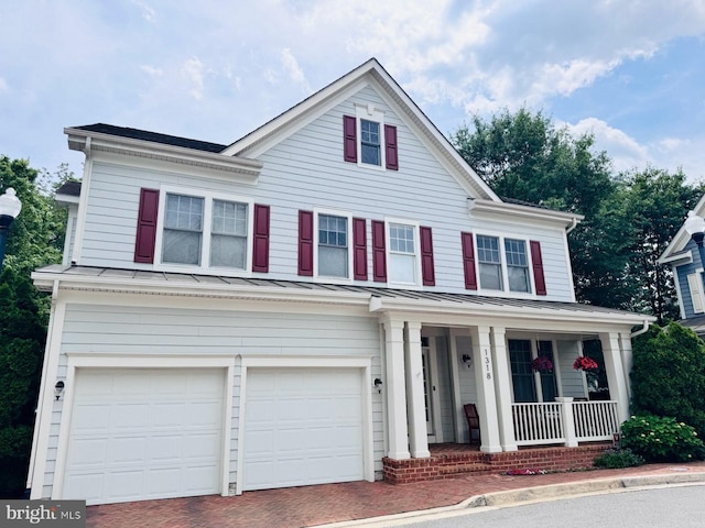 1318 S Kenmore Cir, Arlington, VA 22204 - view of front of home with covered porch, a standing seam roof, an attached garage, decorative driveway, and metal roof