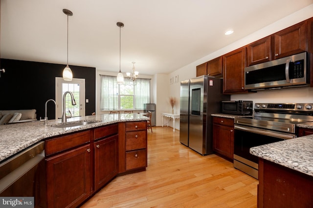 3237 Walnut St, Downingtown, PA 19335 - kitchen featuring stainless steel appliances, a sink, light wood-style flooring, a chandelier, and pendant lighting