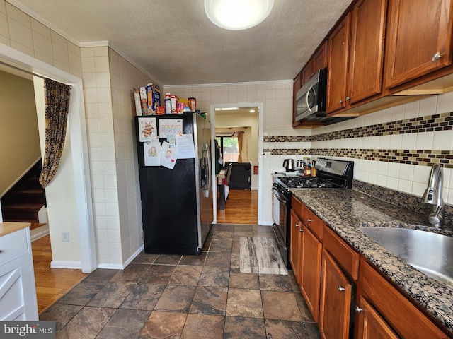 74 Probasco Rd, Hightstown, NJ 08520 - kitchen with appliances with stainless steel finishes, a sink, a textured ceiling, brown cabinets, and tasteful backsplash