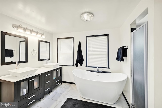15 Homberg Ave, Baltimore, MD 21221 - full bath with marble look tile flooring, a freestanding bath, double vanity, and baseboards