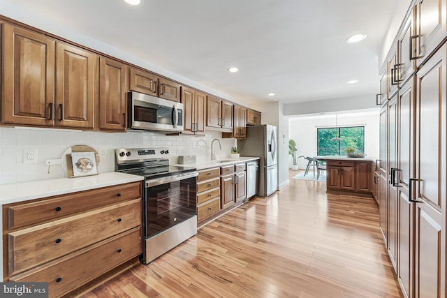 2127 Cabots Point Ln, Reston, VA 20191 - kitchen featuring appliances with stainless steel finishes, light wood-style flooring, backsplash, light countertops, and recessed lighting
