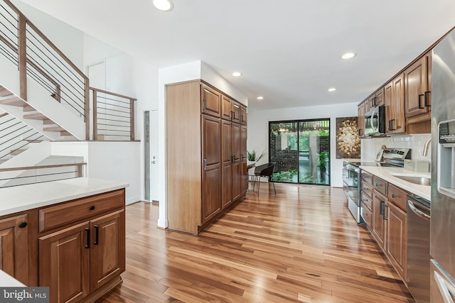 2127 Cabots Point Ln, Reston, VA 20191 - kitchen featuring appliances with stainless steel finishes, light wood-style floors, recessed lighting, tasteful backsplash, and light countertops