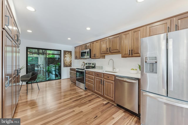 2127 Cabots Point Ln, Reston, VA 20191 - kitchen with stainless steel appliances, light countertops, light wood-style flooring, recessed lighting, and brown cabinets