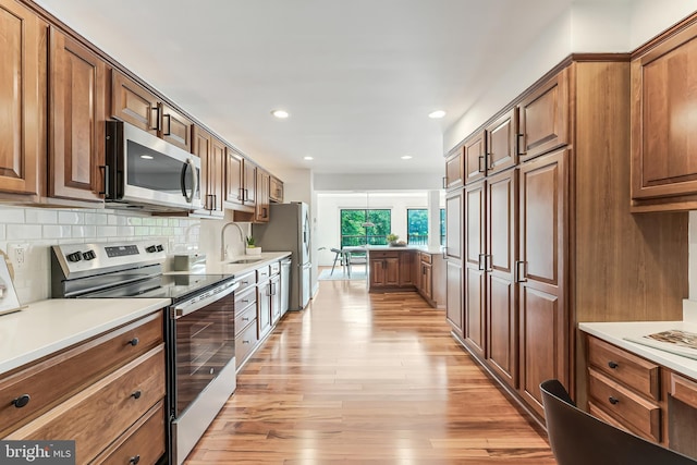 2127 Cabots Point Ln, Reston, VA 20191 - kitchen featuring stainless steel appliances, light wood finished floors, decorative backsplash, light countertops, and recessed lighting