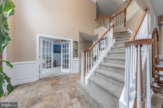 11 Harvest Dr, Pittsgrove, NJ 08318 - staircase featuring french doors, stone finish flooring, ceiling fan, a decorative wall, and wainscoting